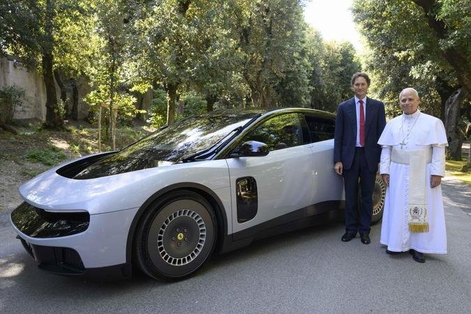 O presidente da Ferrari, John Elkann, e o Papa Le�o XIV: pont�fice n�o escondeu a felicidade ao assumir o banco do piloto(foto: Ferrari/Divulga��o)