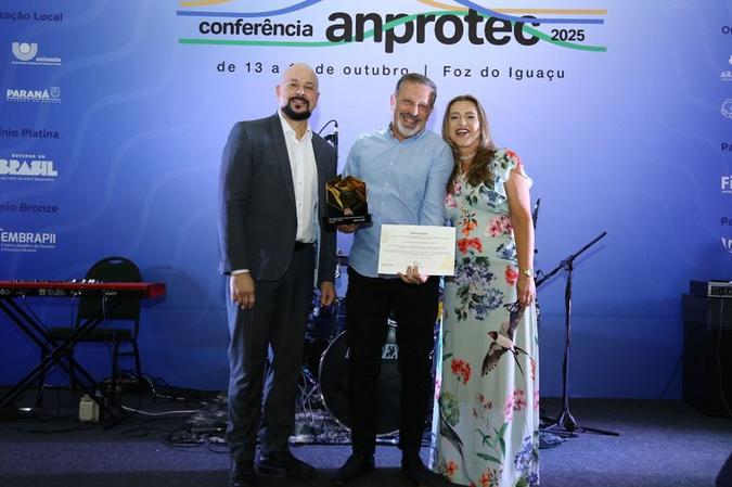 Marco Crocco (ao centro) recebeu o prêmio da presidente da Anprotec, Adriana Ferreira de Faria(foto: Divulgação) Marco Crocco (ao centro) recebeu o prêmio da presidente da Anprotec, Adriana Ferreira de Faria(foto: Divulgação)