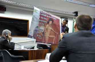 O pastor Joide Pinto Miranda segura cartaz com foto da poca em que era travesti: 