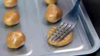 Aps fazer as bolinhas da 'massa' e colocar na assadeira, que no precisa ser untada, use um garfo para 'achat-las' em dois sentidos diferentes, para dar um acabamento diferenciado(foto: BuzzFeed/Reproduo)