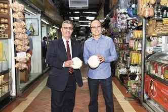 O superintendente Luiz Carlos Braga ( esq.) e o presidente do mercado, Geraldo Henrique Campos, seguram um pedao de queijo: 