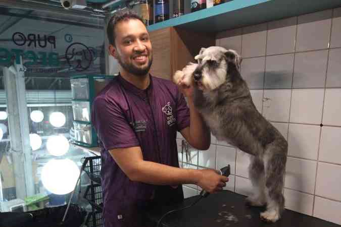 O tosador e gerente Lucas Alves da Cruz, com a schnauzer Peppa, no final do banho da Puro Afeto da rede Dog%u2019s Shop: 