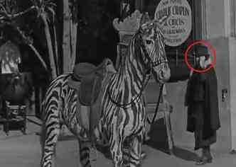 No vdeo da premire do filme O Circo, de Charles Chaplin, uma senhora aparece caminhando e usando um objeto similar a um aparelho celular(foto: YouTube/Reproduo)